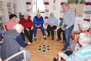 Die Teilnehmer im Stuhlkreis beim Wurfspiel