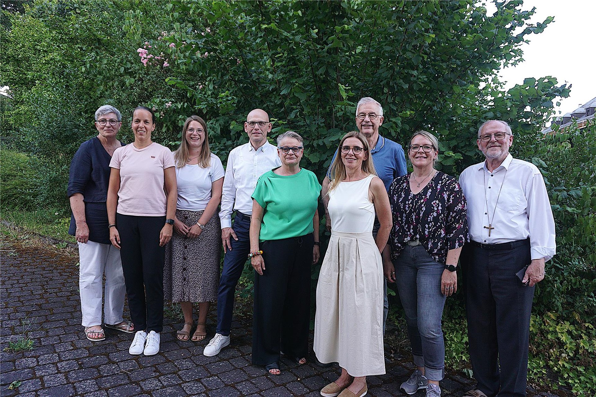 Gruppenfoto des AGH-Vorstandes vor einer grünen Hecke.
